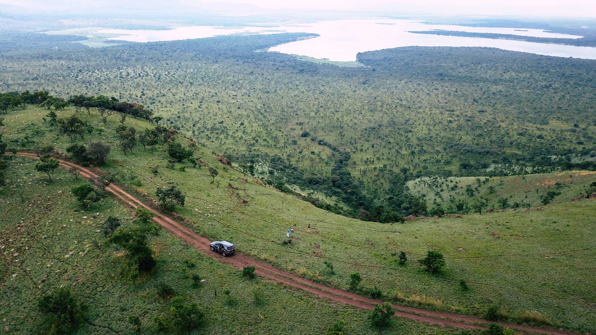 Vue panoramique du parc national de l'Akagera avec jeep et lac dans le fond